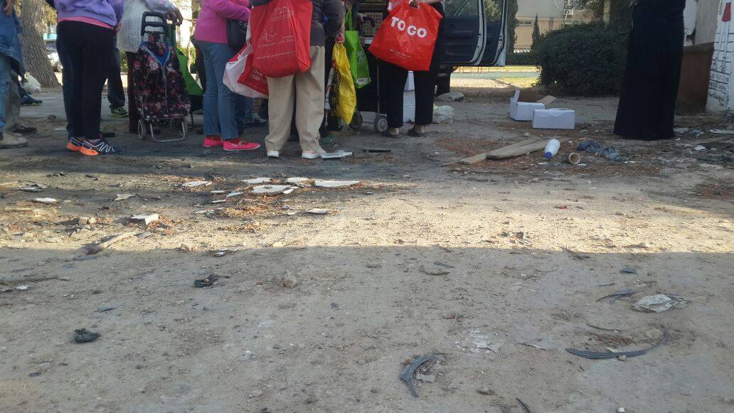 מבוגרים וצעירים, מחכים בתור, לטנדר שיביא להם מעט חיוך לחיים שלהם (צילום: חן המאירי)